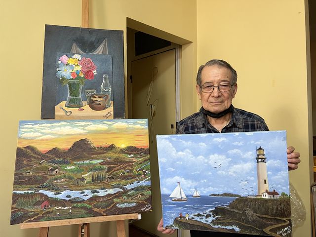 Ray Cortez with oil paintings he produced in retirement.